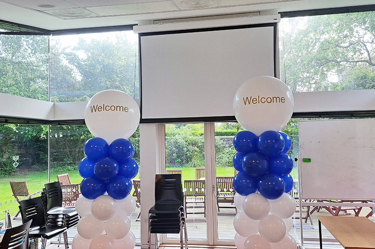 Two sets of balloons in the XL room at Kinnessburn with 'Welcome' written across the front.